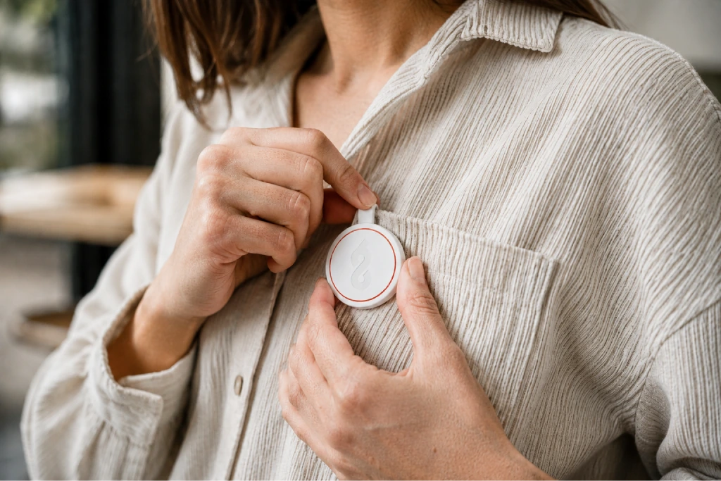 A clinician clipping ChartScribe Pin to a shirt pocket.
